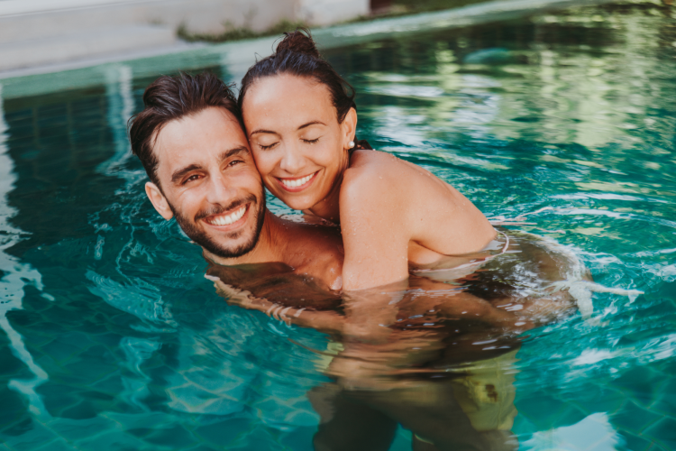 young couple enjoying a day swimming at the pool