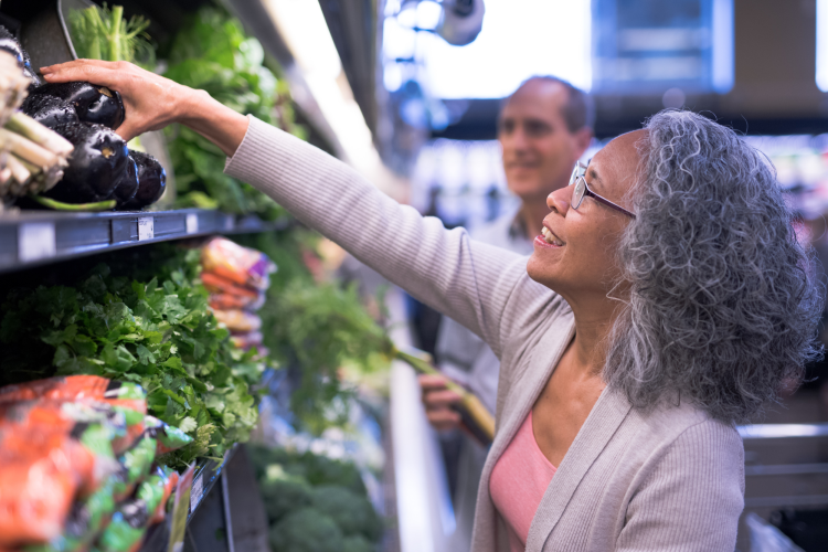 woman buying eggplant in grocery store