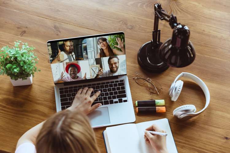 remote workers waving at team members through video chat