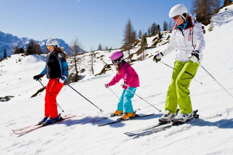 two women and one young girl skiing in the snow