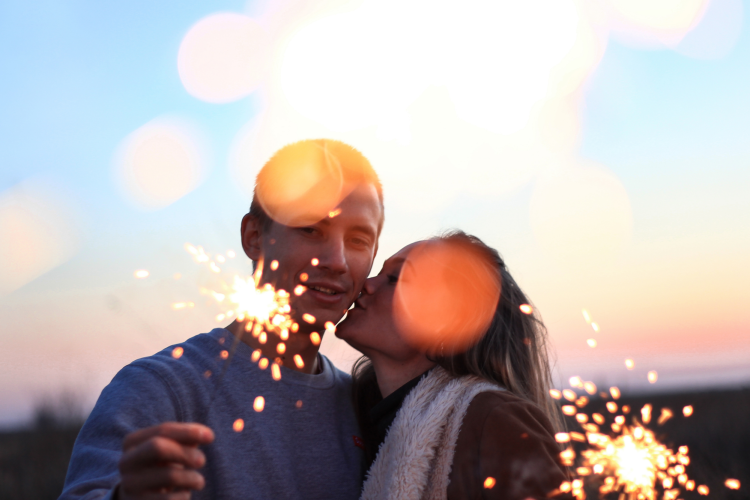 couple holding sparklers at twilight