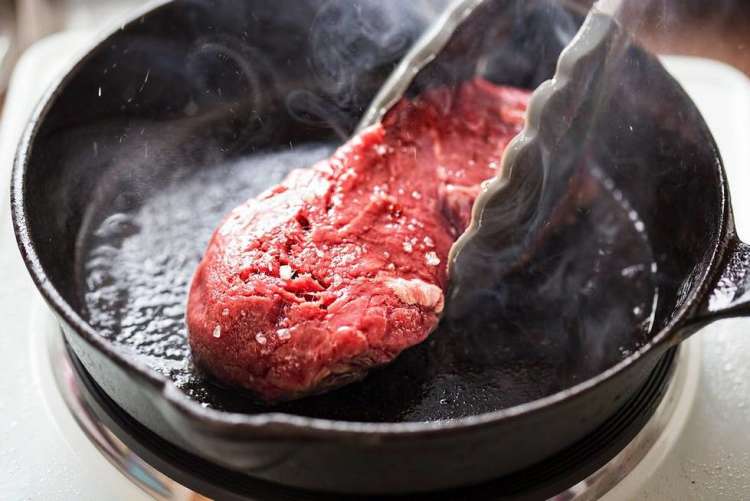 cooking steak in a pan