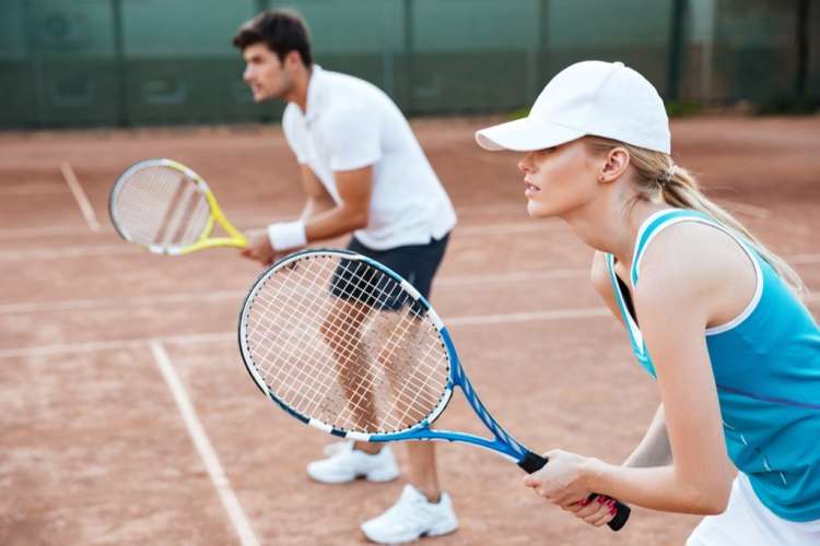 couple playing tennis together on a court