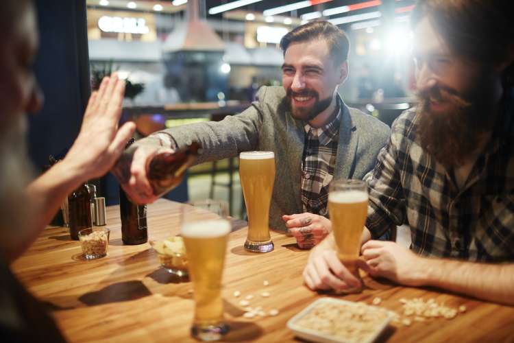 friends playing trivia in a bar with beers