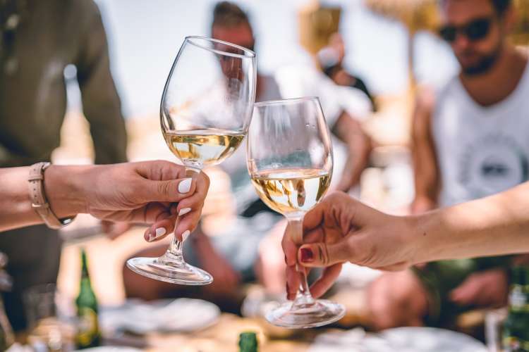 friends enjoying white wine at an outdoor dinner party