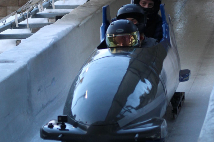 three helmeted people ride a bobsled at Utah Olympic Park