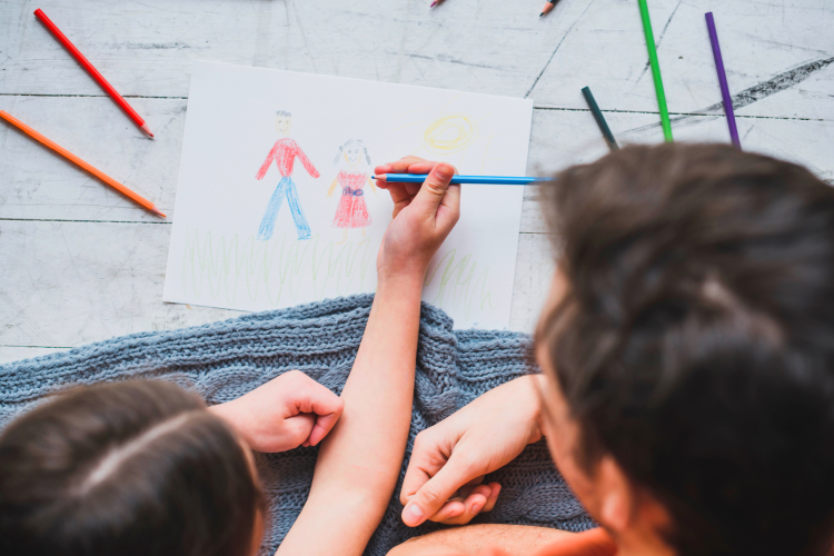 girls drawing a picture with her dad