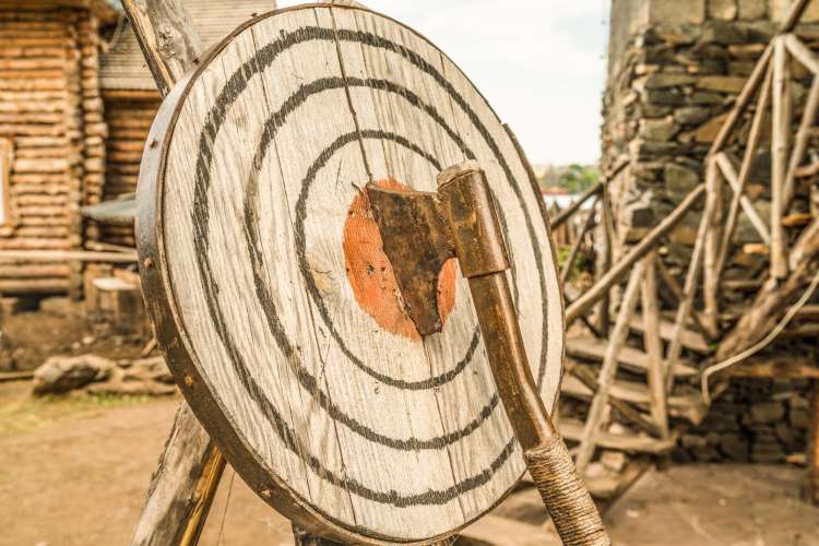 an axe stuck in the bullseye of a round, wood target