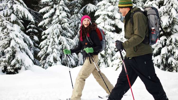 couple snowshoeing through the mountains