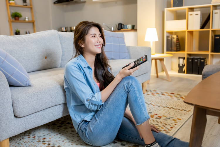 young woman watching tv while sitting on the floor