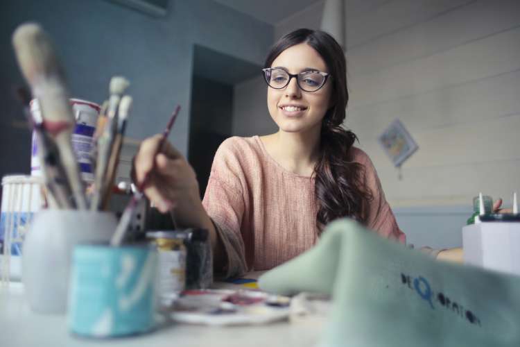 woman painting a picture during a virtual birthday party