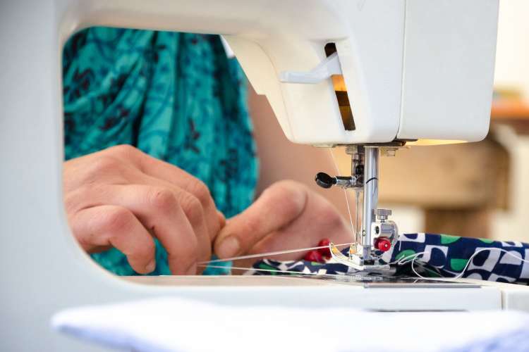 hands on fabric under sewing machine