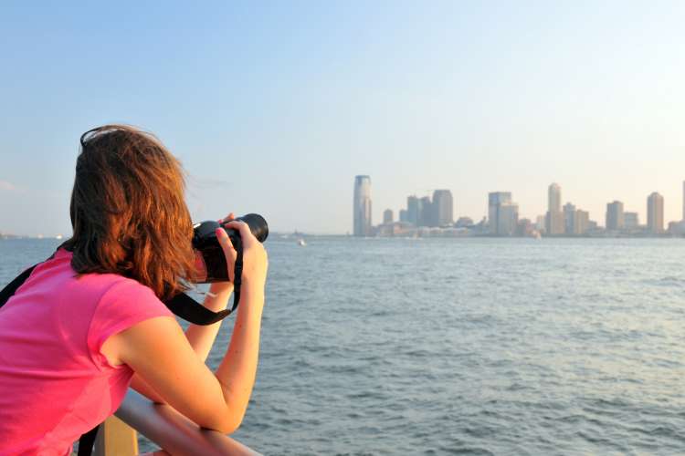 woman taking photo of New York City skyline
