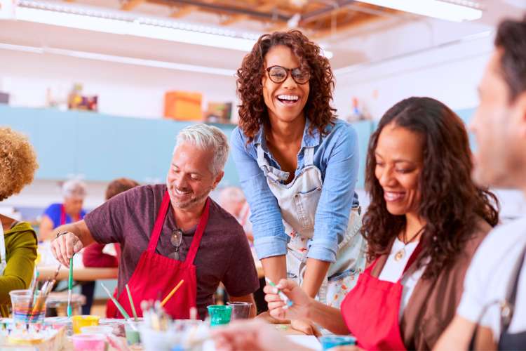 students and art teacher smiling in art studio