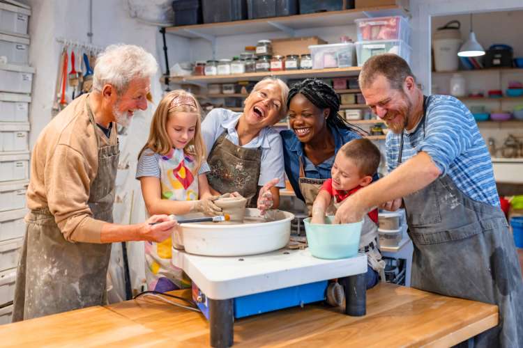 group of people of different ages smiling in pottery classes in Chicago