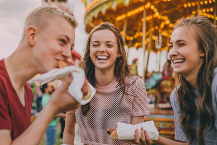 Teens eating hot dogs