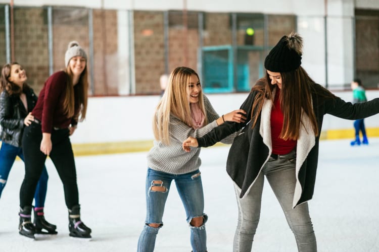 Teenage girls ice skating in winter.