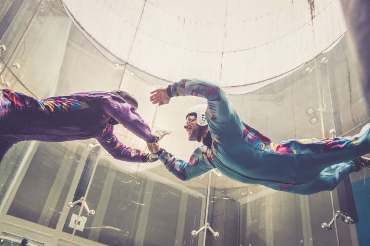 Indoors skydiving -instructor teaching how to fly - freefall simulation.