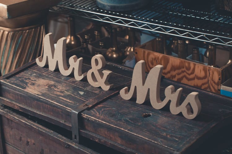 mr and mrs wooden signs hang off the back of two chairs
