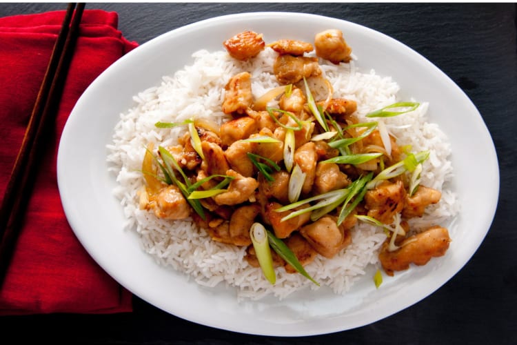 Kung pao chicken, vegetables and spring onions to garnish