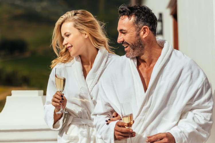 A couple in bath robes with Champagne glasses at a spa