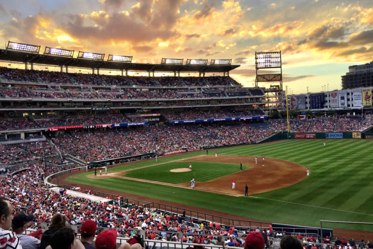 A baseball field with a game in play at sunset