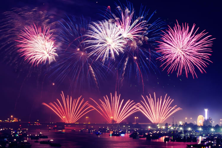 Red, white and blue fireworks over the water
