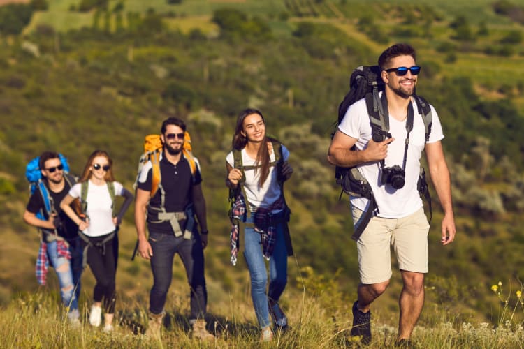 People hiking along a grassy trail