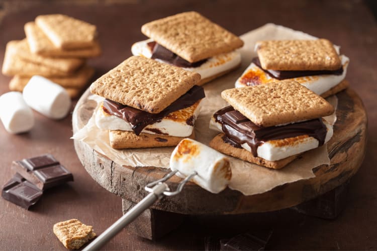 S'mores next to uncooked chocolate and marshmallows