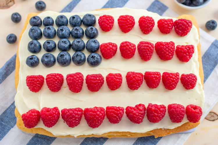 A cake with berries decorating it like a US flag