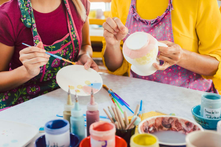 Two people painting pottery