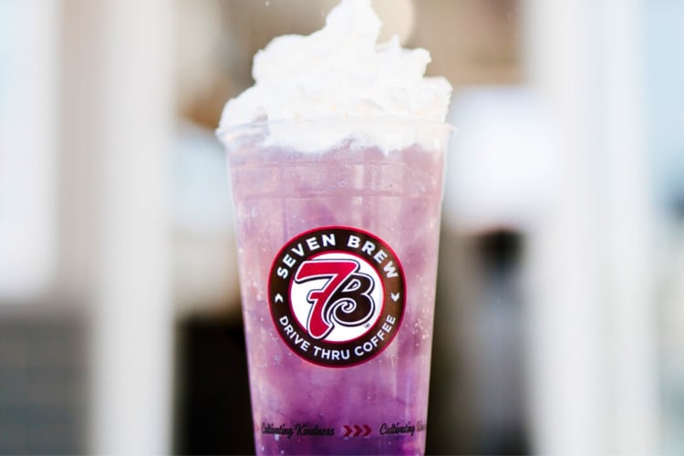 A purple drink with whipped cream on top