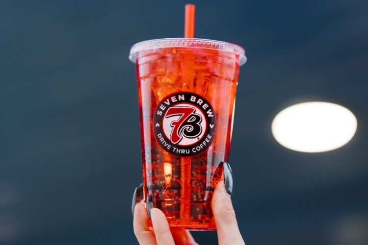 A red drink in a clear take-out cup