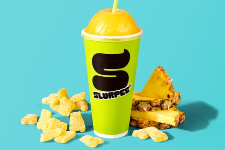 A 7-Eleven Slurpee next to candied and fresh pineapple