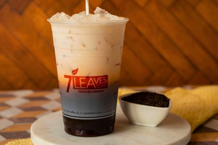 An iced black coffee with cream topping