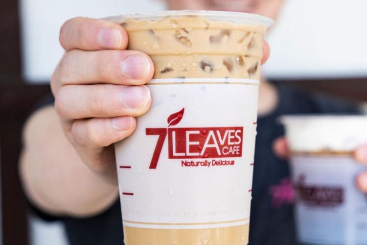 A person holding a caramel and coffee iced drink