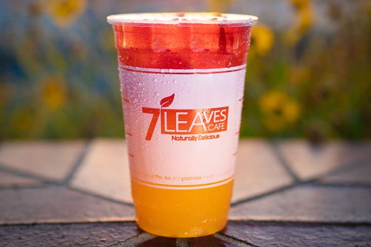 A pink and orange drink in a clear cup