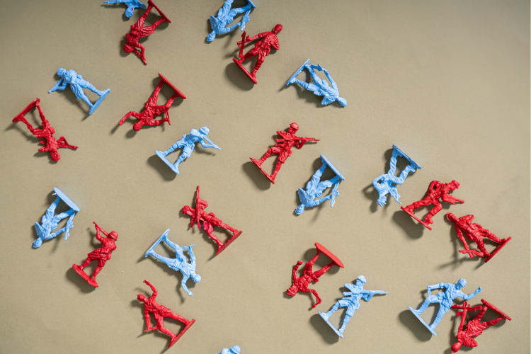 red and blue toy soldiers lie scattered across a surface