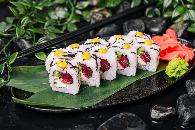 10 tuna maki rolls on a banana leaf on a plate