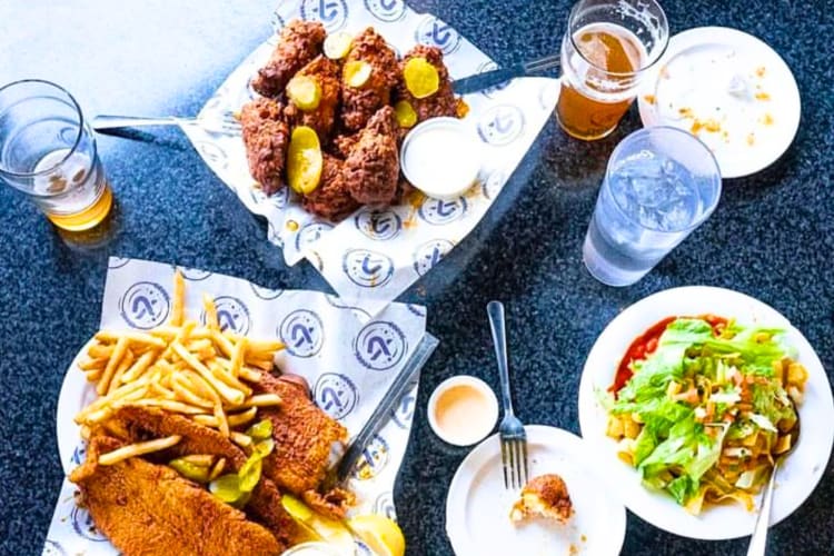 Fried chicken, fish and chips and a salad on a table