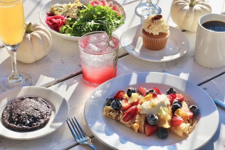 Breakfast dishes, a cupcake and cocktails on a table