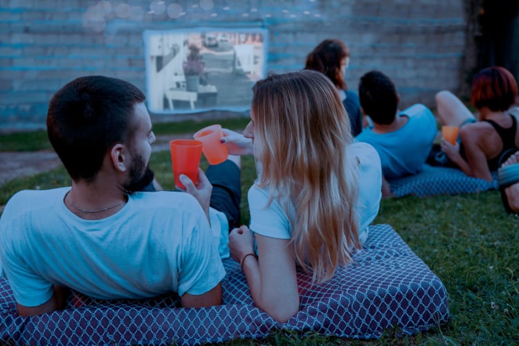 friends enjoying an outdoor movie in the grass