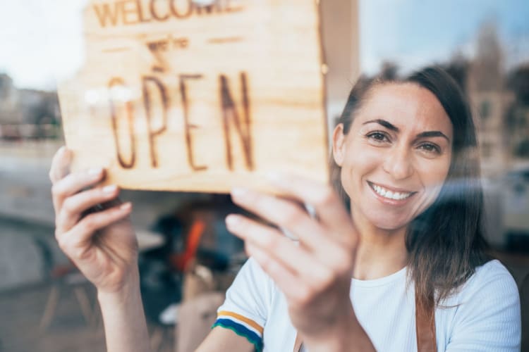 a smiling woman opening her business