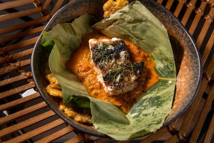 Portion of meat on a bed of sauce in a leaf from the D.C. restaurant Amazonia