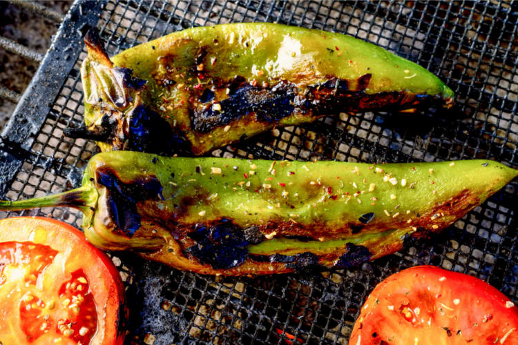 Anaheim peppers on a grill with tomatoes