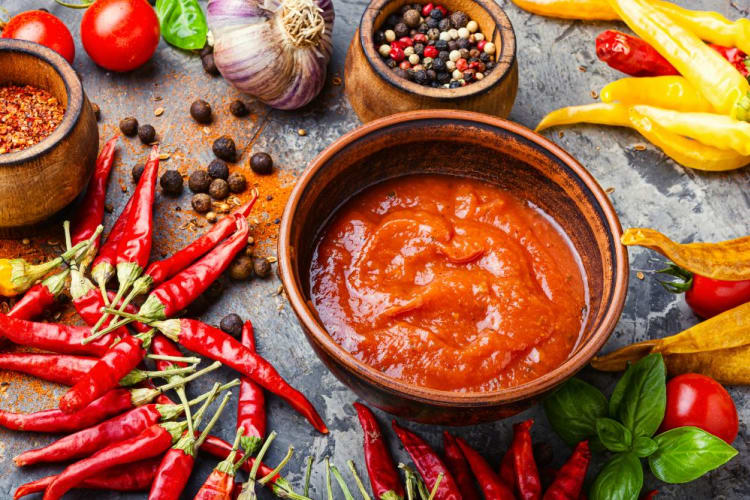 Anaheim peppers and other ingredients next to a bowl of salsa