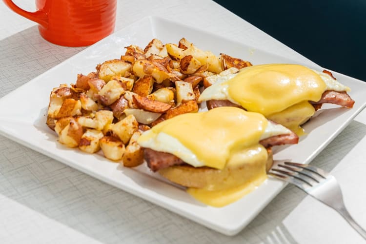Eggs Benedict meal with potato bites, from Anna’s House