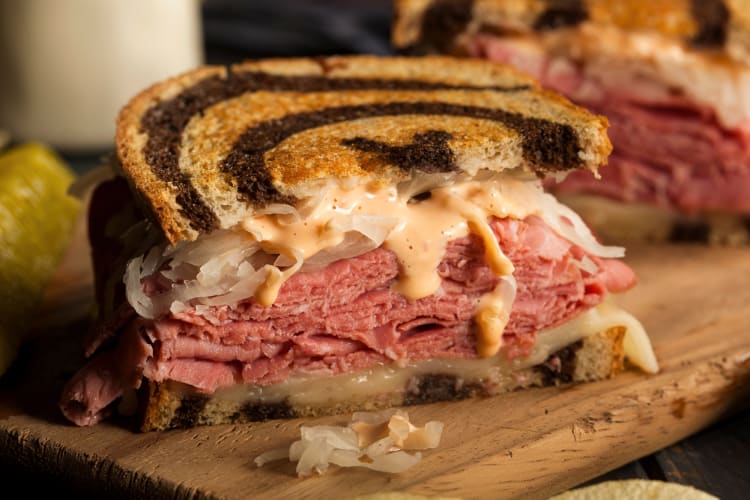 A Reuben sandwich on a wooden board