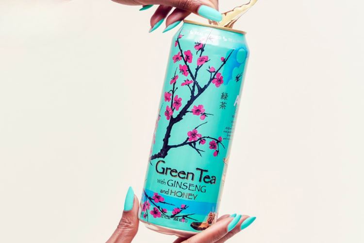 A person opening a can of Arizona Green Tea With Ginseng and Honey