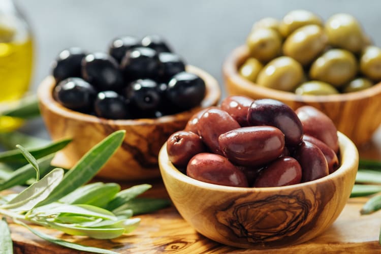 Wooden bowls with different kinds of olives